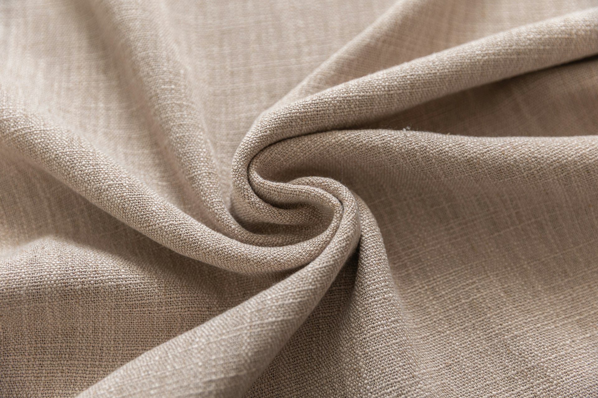 Close-up of beige textured fabric folded into a swirl.